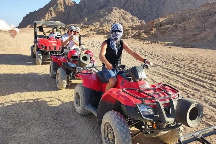 Un groupe de touristes faisant du VTT rouge sur un sentier désertique accidenté à Charm el-Cheikh